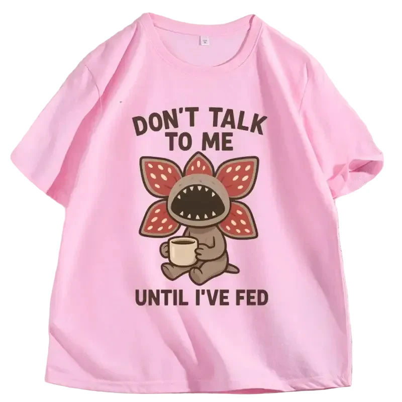 T-shirt démogorgon humour rose avec illustration cartoon et texte ne me parle pas avant que jai mangé en brun foncé