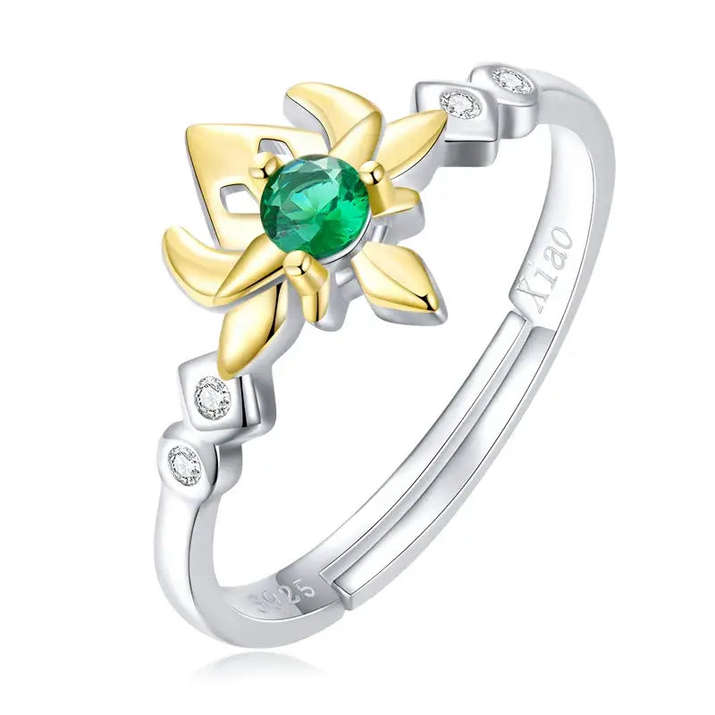 Bague argent genshin impact avec émeraude centrale, pétales dorés et petits brillants sur anneau argenté