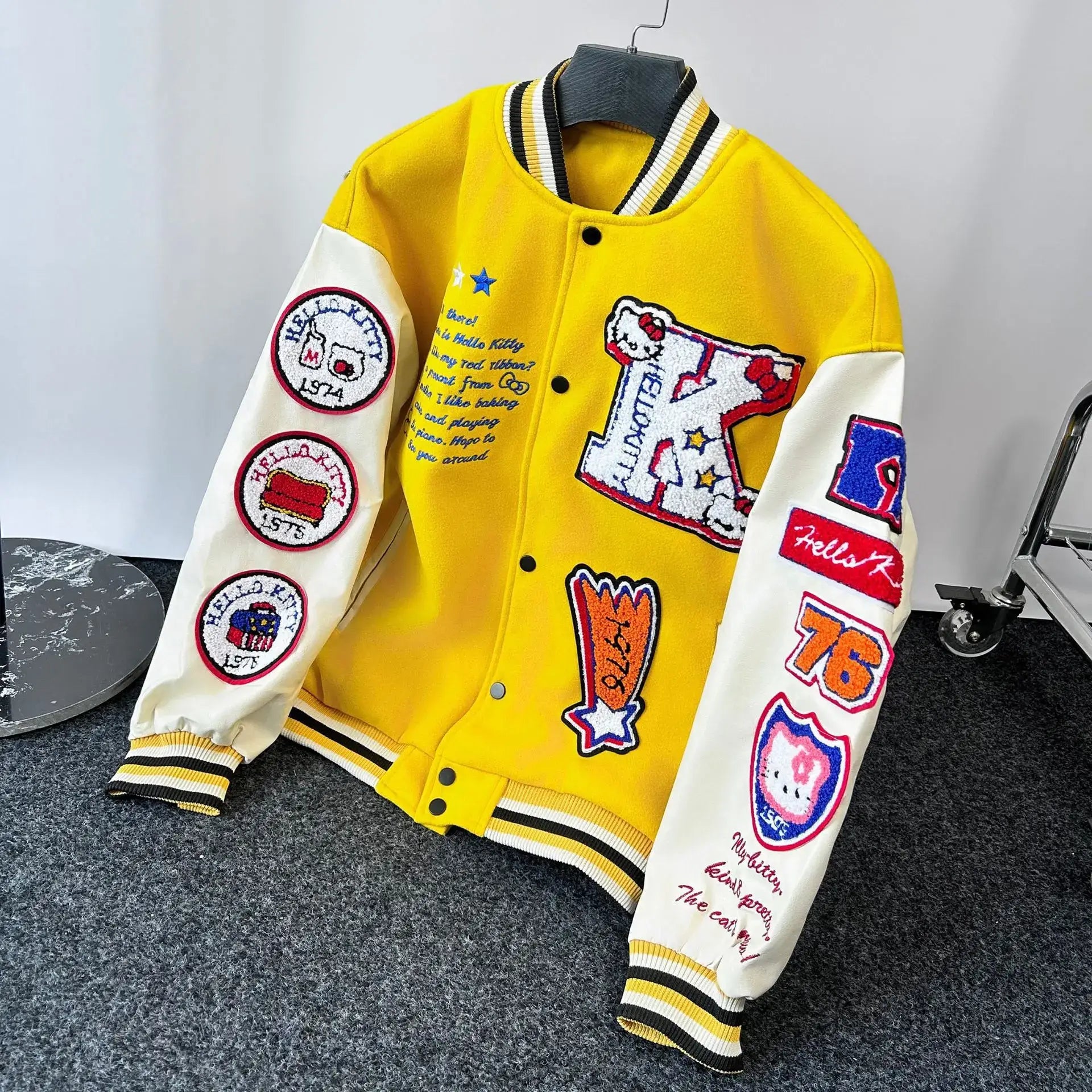 Blouson Hello Kitty baseball jaune et crème avec patchs brodés colorés offrant confort optimal et détails soignés