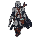 Broches pins star wars représentant le mandalorian en armure blanche et noire avec accents rouges tenant grogu