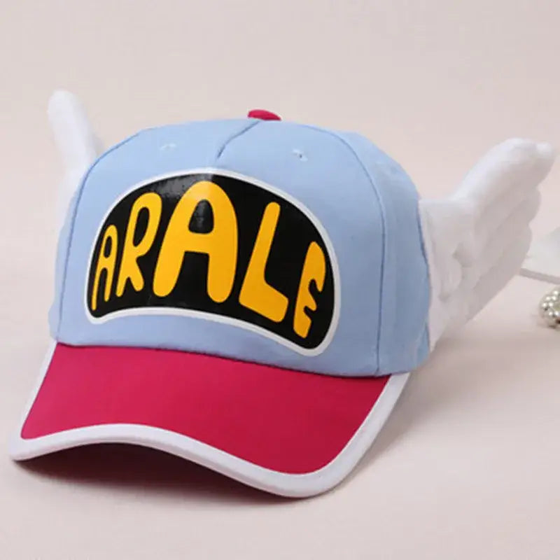 Casquette coton enfant anime dr slump bleu clair et rose avec ailes blanches et logo jaune arale sur le devant