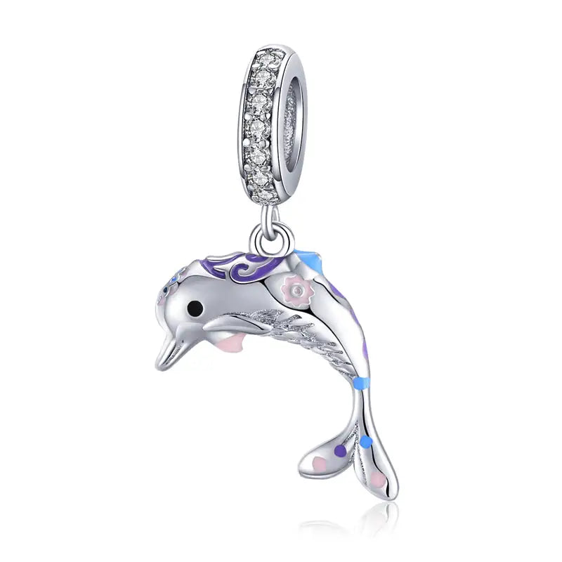 Charms océan en argent avec dauphin argenté, détails floraux roses, émail violet et bleu, anneau en cristaux scintillants