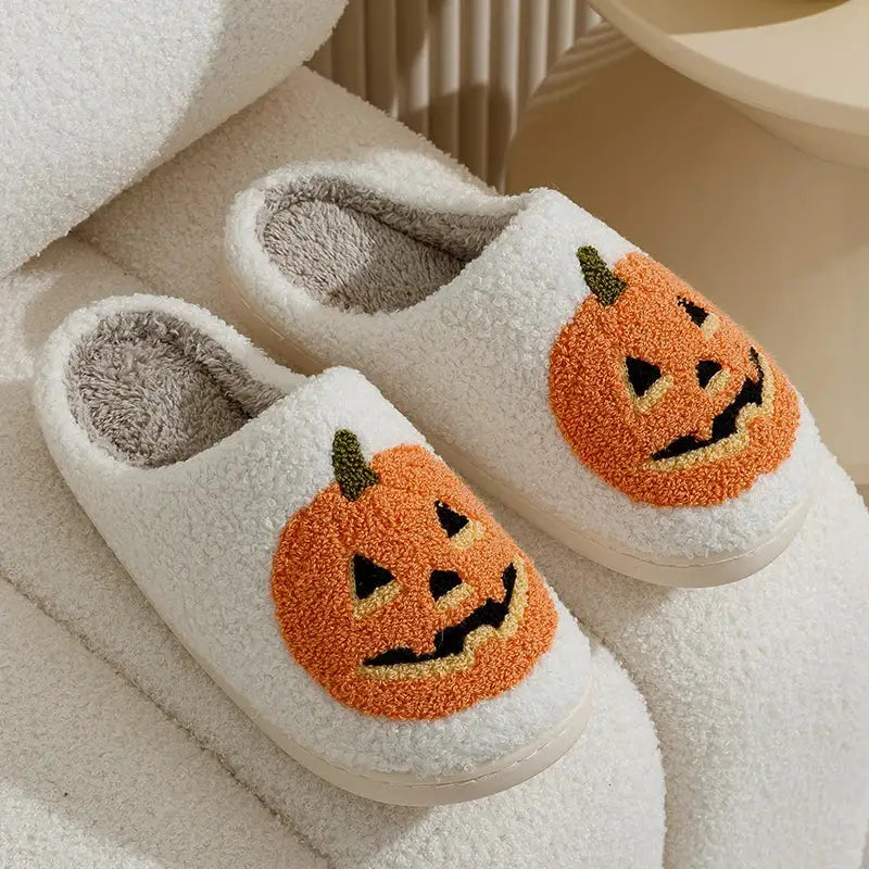 Chaussons femme hiver blancs en peluche avec visages de citrouilles brodés orange et tiges vertes pour halloween