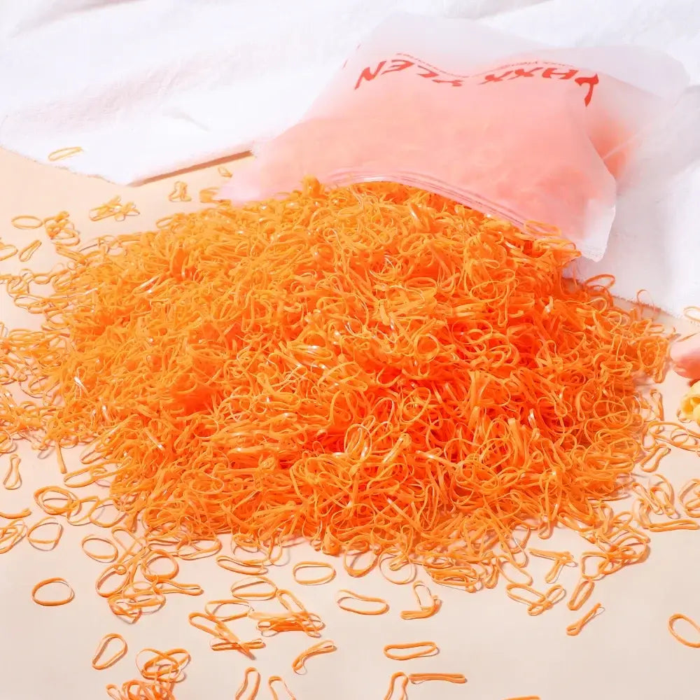 Une pile de 500 elastiques orange en plastique transparent pour loisirs créatifs bracelets uniques et déguisement carnaval