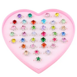Ensemble bagues ajustables enfant fille avec bagues colorées et designs colorés présentées dans boîte rose cœur