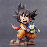 Figurine anime dragon ball z son goku avec cheveux noirs, gi orange, brassards bleus tenant une peluche puar