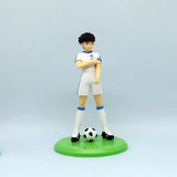 Figurine anime olive et tom captain tsubasa en blanc et bleu sur socle vert avec ballon noir et blanc l’univers d’olive