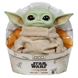 Figurine bébé yoda star wars verte en plastique dans une robe beige présentée sous dôme plastique avec emballage à thème mandalorian