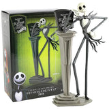 Figurine décorative l’Étrange noël de monsieur jack en noir et blanc posée sur un socle gris avec bras levés style jack charge