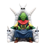 Figurine dragon ball piccolo daimao en robe bleue assis sur un trône blanc avec créatures crâne cornues