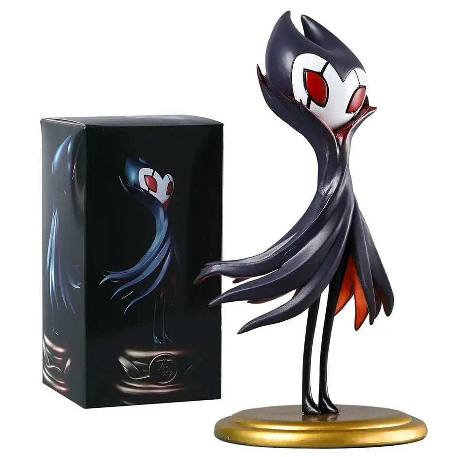 Figurine hollow knight grimm en noir et blanc avec yeux rouges et cape sur socle doré dans boîte illustrée