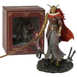 Figurine malenia elden ring dorée avec cape rouge et armure en chaîne détaille posée sur socle rocheux à côté de sa boîte