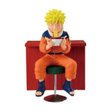 Figurines naruto iruka umino montrant naruto en combinaison orange assis sur un tabouret vert mangeant des nouilles au restaurant ichiraku