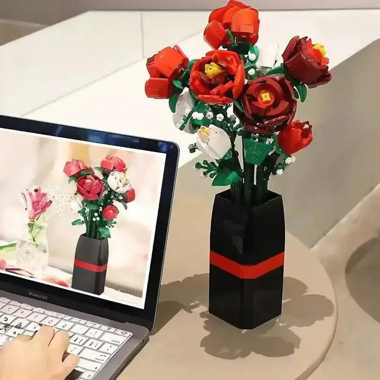 Un vase lego noir avec une bande rouge contenant un bouquet de lego fleurs rose rouge pour jeu construction vase rose rouge