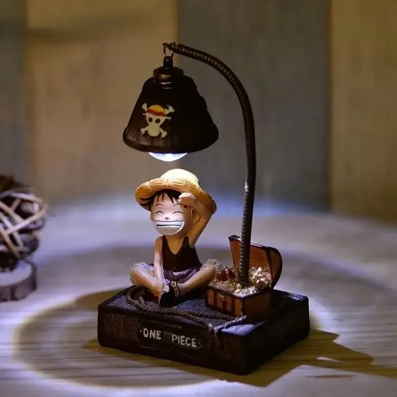 Lampe bureau one piece noire avec col flexible et logo tête de mort au-dessus d’une figurine souriante de luffy l’anime one piece