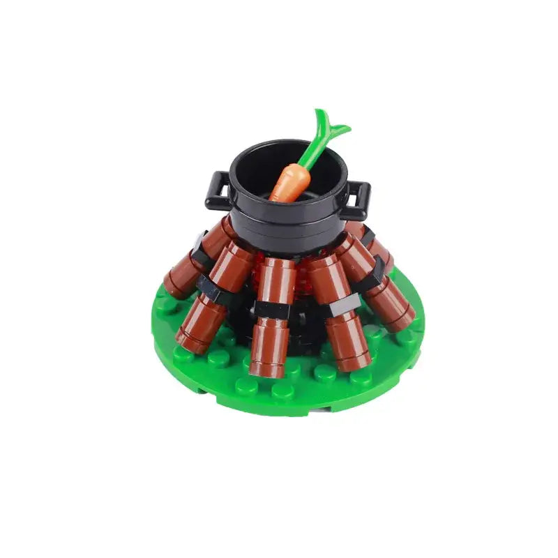 Lego moc medieval comprenant un feu de camp en brique marron lego avec pot noir et carotte orange sur base verte