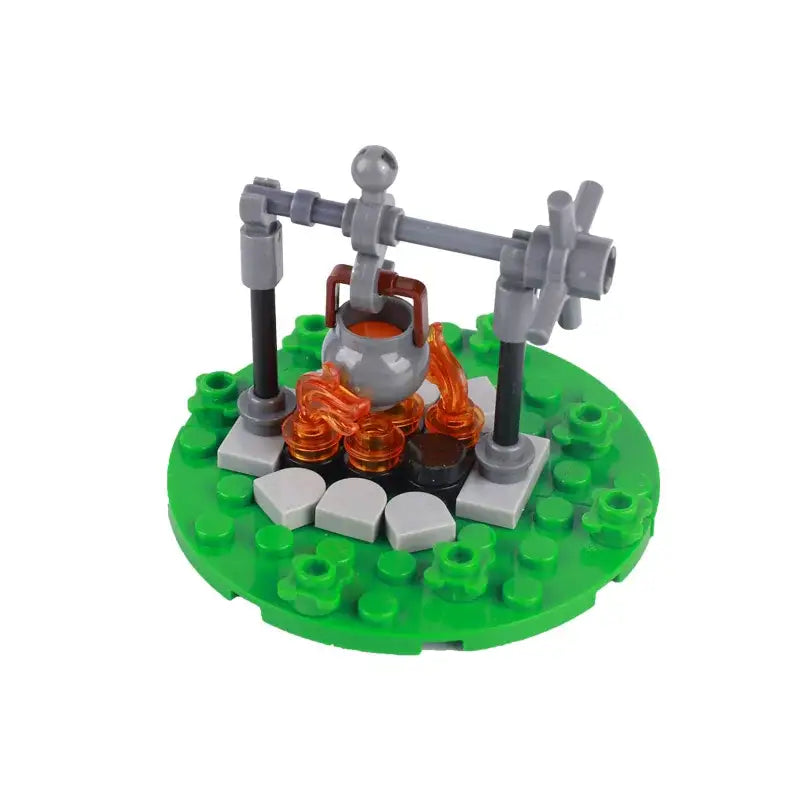 Lego moc medieval avec pot gris suspendu au-dessus dune flamme orange translucide sur une base verte pour déguisement carnaval