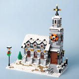 Lego moc décor de noël avec église en briques grises, toit enneigé, horloge orange et porte marron