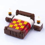 Lego moc lit marron avec couverture à carreaux rouge et jaune et deux lego meubles tables de nuit avec lampes blanches