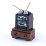 Lego moc accessoire lego télévision brique noire avec antennes grises et écran motif test coloré sur meuble brun