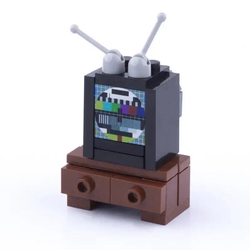 Lego moc accessoire lego télévision brique noire avec antennes grises et écran motif test coloré sur meuble brun