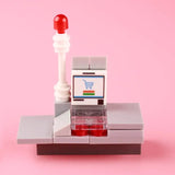 Comptoir de caisse lego moc gris avec poteau rouge et écran affichant une icône de caddie pour lego fruits et lego legumes