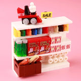 Présentation lego moc magasin supermarché avec étagère miniature blanche contenant bouteilles colorées, céréales lego fruits et légumes, pop-corn, hot-dogs et petit train rouge