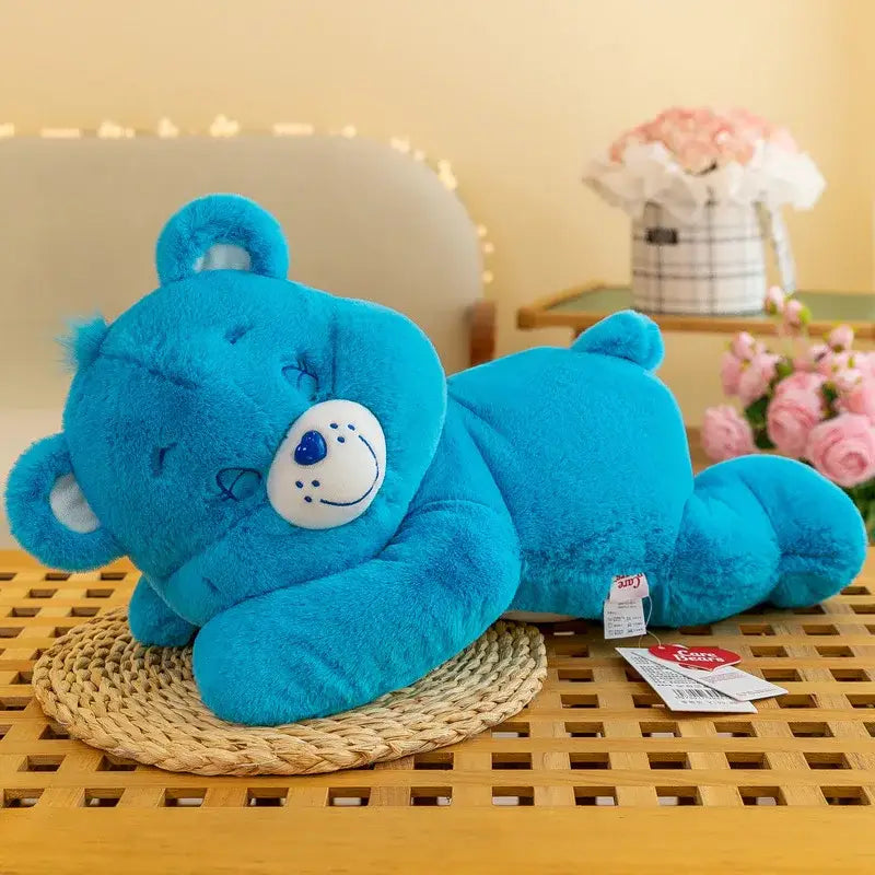 Plush peluche bisounours dodo calin bleu avec museau blanc et yeux fermés allongé sur le côté