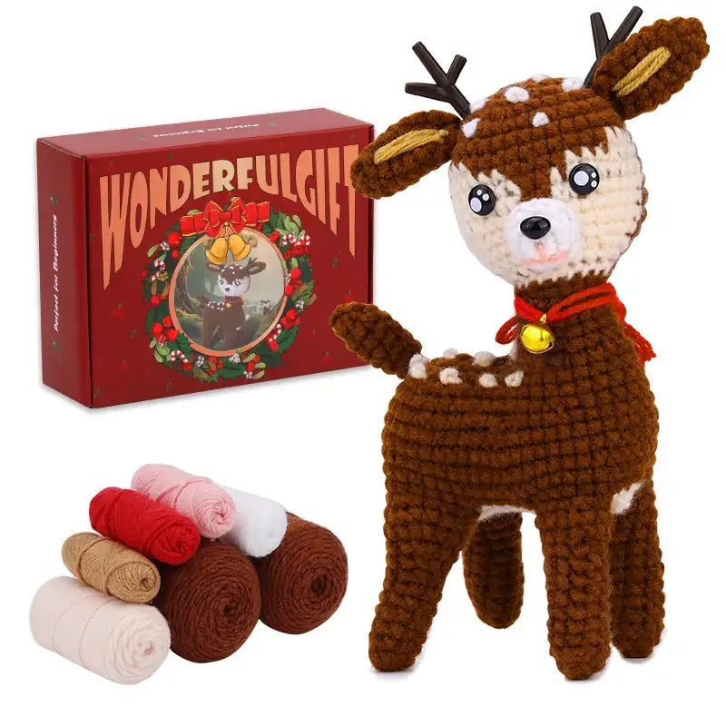 Peluche crochet déco de noël représentant un cerf marron à taches blanches et bois noirs avec foulard rouge et clochette dorée