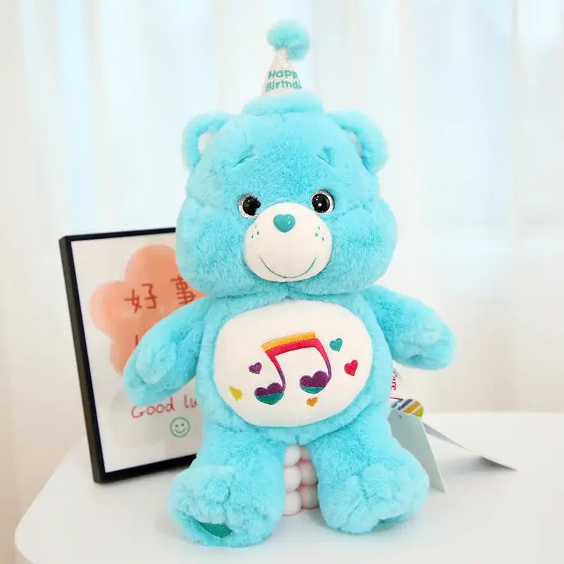 Peluche doudou bisounours calinours bleu clair avec note musicale arc en ciel et chapeau de fête sur le ventre