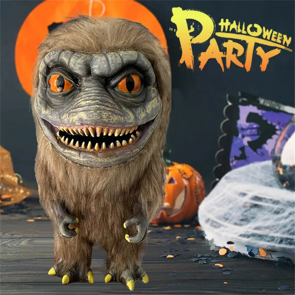 Peluche horreur critters 25cm gris brun avec yeux orange et griffes jaunes dans décor halloween
