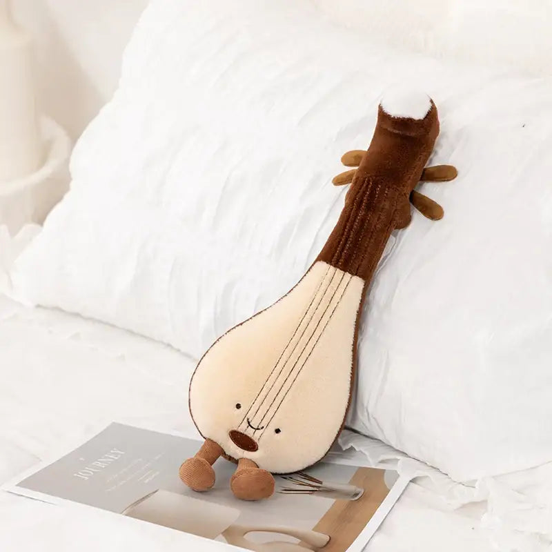 Peluche instrument de musique 30cm doux en marron et crème avec visage souriant et petites pieds parfait pour déguisement carnaval