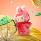 Une peluche labubu pop mart rose en peluche avec fourrure duveteuse et grand yeux expressifs en tenue à capuche assortie