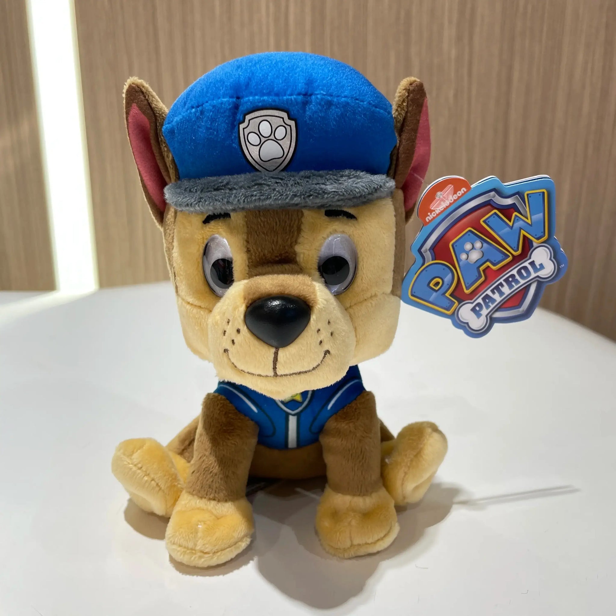 Peluche pat patrouille chase en peluche avec corps beige et taches marron portant casquette et gilet bleu du héros canin préféré