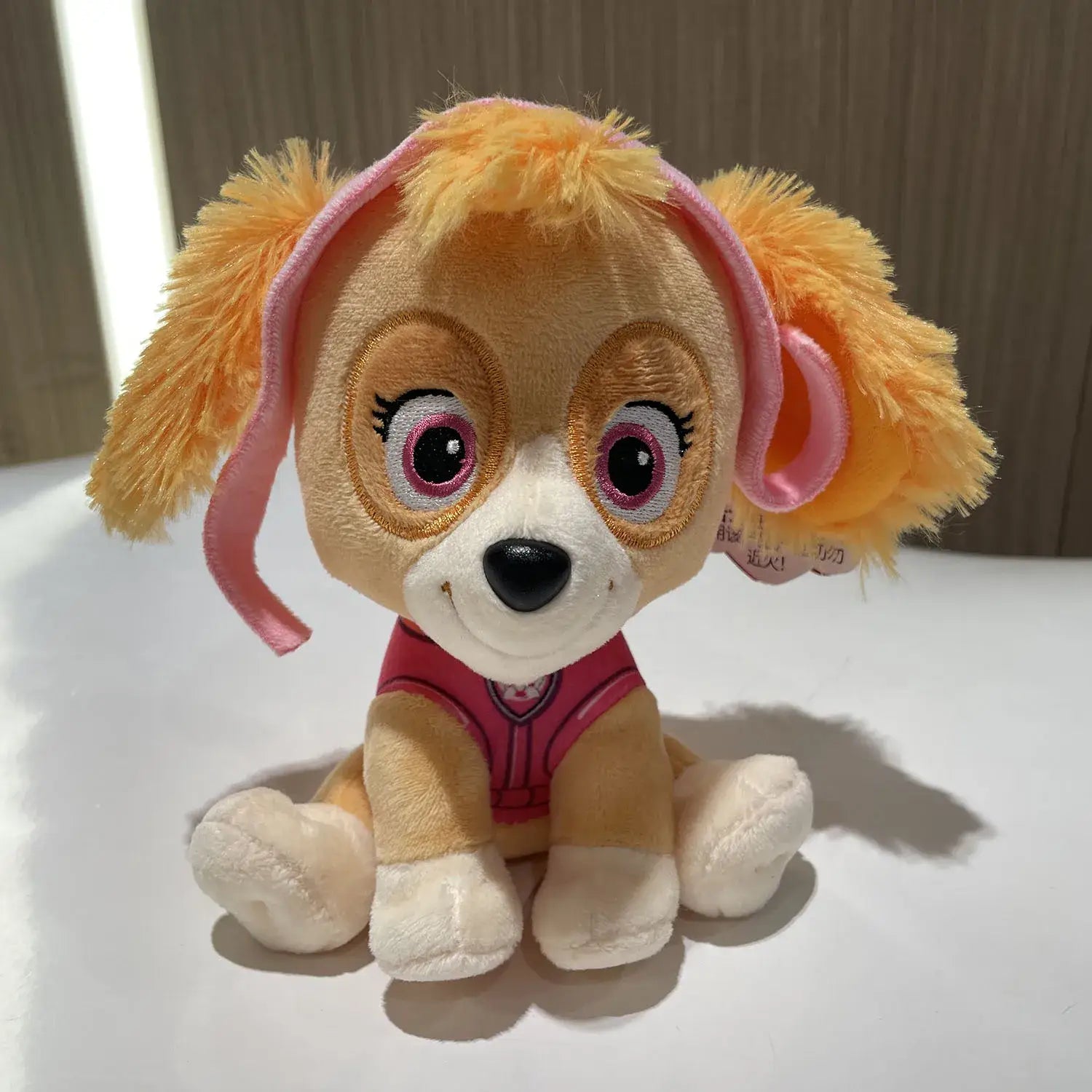Peluche pat patrouille skye en peluche avec fourrure orange douce, nœuds roses et gilet rose, héros canin préféré