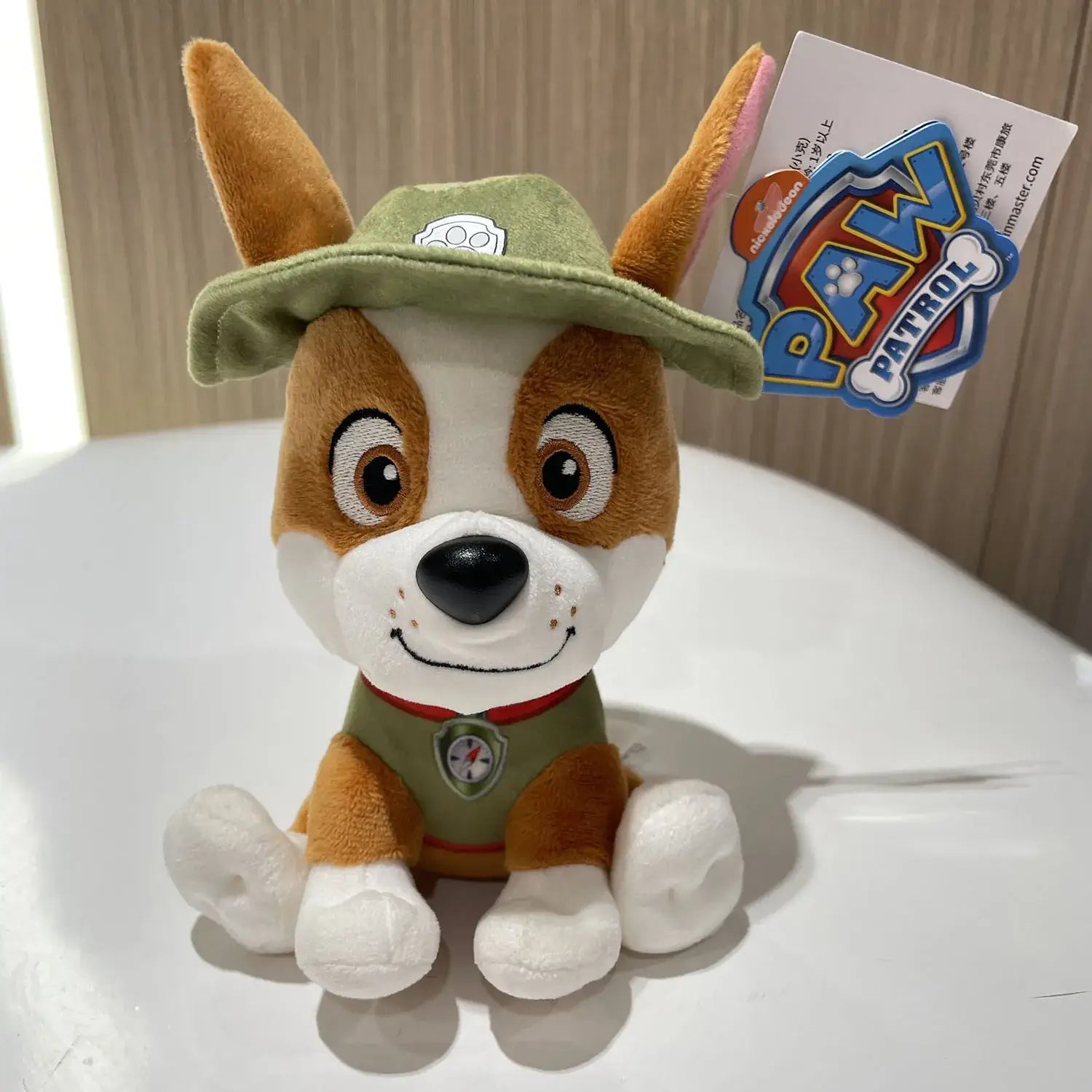 Peluche pat patrouille chien en peluche marron et blanc avec chapeau vert et gilet avec emblème pat patrouille