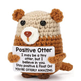 Peluche loutre calin en crochet marron et crème tenant un panneau blanc peluche crochet douce et charmante