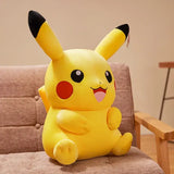 Un peluche pikachu xxl jaune avec oreilles noires et joues rouges assis sur une chaise rembourrée compagnon idéal pokemon