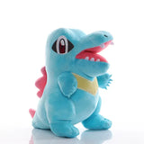 Peluche pokémon totodile kaiminus bleue en peluche avec nageoire rose, ventre jaune et bouche rouge ouverte