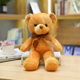 Un peluche teddy bear couleur marron clair avec peluche douce et noeud assorti posé sur des livres