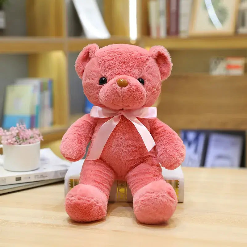 Peluche teddy bear couleur rose doux en tissu peluche avec yeux boutons noirs et noeud satin blanc élégant