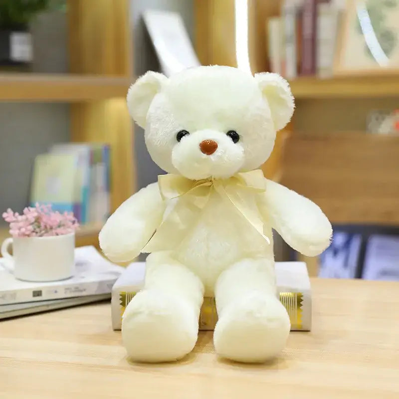 Peluche teddy bear couleur crème avec yeux boutons noirs nez marron et ruban assorti autour du cou
