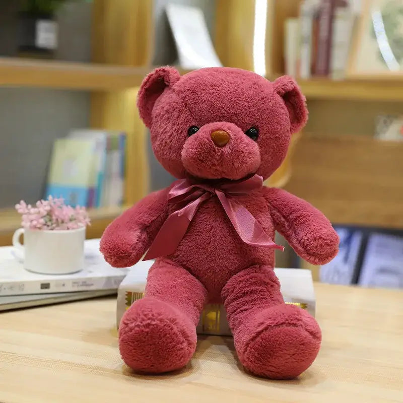 Peluche teddy bear couleur rose en peluche avec un ruban en satin autour du cou