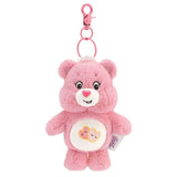 Porte-clé peluche bisounours rose avec texture douce, yeux et nez brodés, patch blanc cœur cousu sur le ventre