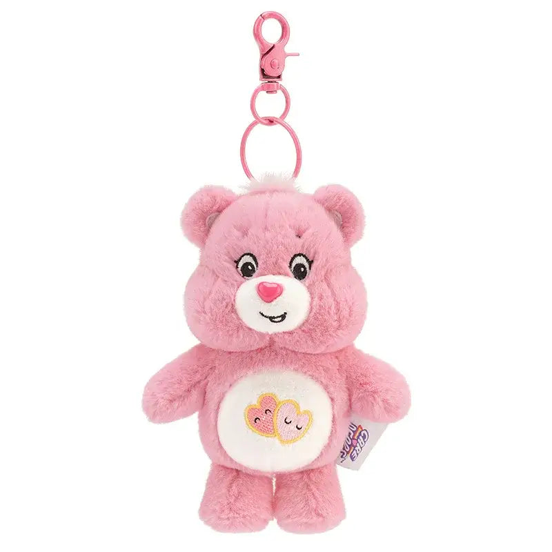 Porte-clé peluche bisounours rose avec texture douce, yeux et nez brodés, patch blanc cœur cousu sur le ventre