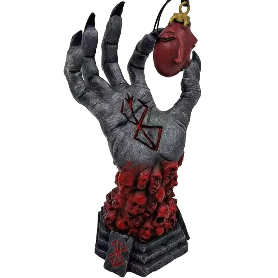 Statue berserk en résine main gris foncé texturée ongles noirs avec masque rouge sur socle de crânes emblématique kentaro miura dark fantasy