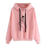 Sweatshirt à capuche love money rose avec cordons noirs et motif minimaliste main faisant le geste finger heart