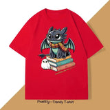 T-shirt anime rouge avec illustration drôle de dragon toothless portant lunettes et écharpe sur livres avec hibou