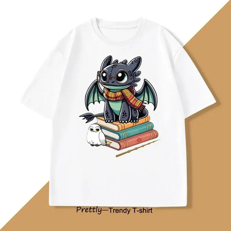 T-shirt anime blanc en coton avec design cartoon de toothless portant une écharpe rayée assis sur des livres avec une chouette