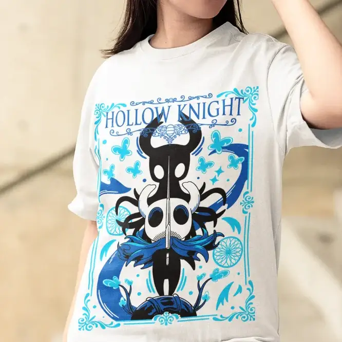 T-shirt hollow knight blanc avec design sombre en bleu et noir et bordures florales pour jeu vidéo hollow knight